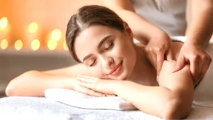Uśmiechnięta kobieta zrelaksowana leży na stole do masażu podczas masażu relaksacyjnego